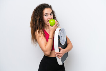 Young Arab woman isolated on white background with weighing machine and with an apple