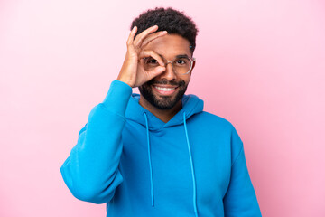 Young Brazilian man isolated on pink background With glasses with happy expression