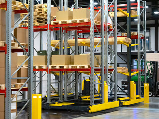 Modern warehouse space. Various shelving stands side by side. Warehouse racks with slabs filled with boxes. Wooden boards are kept in background. Concept sale warehouse equipment. Long term storage