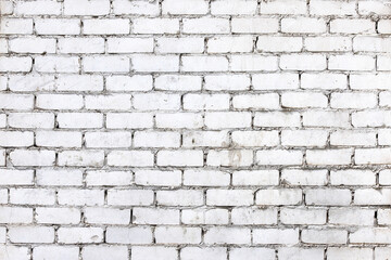 An old damaged wall made of white bricks as a background