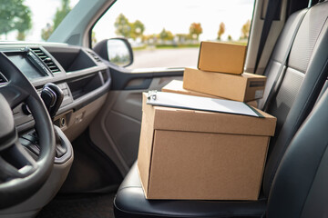 delivery box in minivan. Delivery box as symbol of courier logistics. Concept - delivery of goods from online stores. Courier logistics of online store. Cardboard boxes in driver's seat of van
