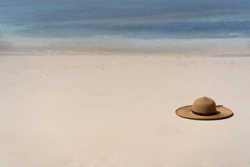 Straw hat on the white sand of the Maldivian beach. Copy space
