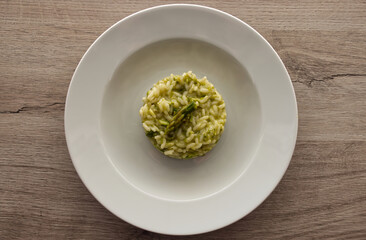 Italian risotto with asparagus. Creamy asparagus risotto on wooden background.