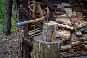 An axe driven into a stump. Preparing firewood. Chopping wood on a stump.