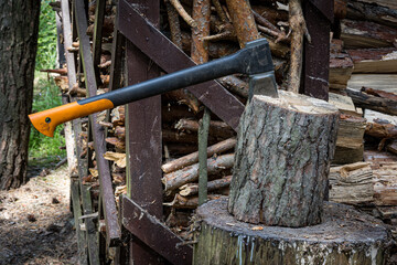 An axe driven into a stump. Preparing firewood. Chopping wood on a stump.