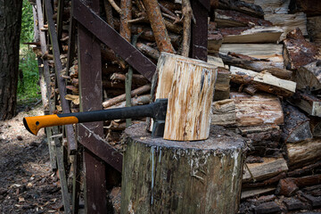 An axe driven into a stump. Preparing firewood. Chopping wood on a stump.