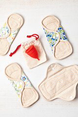 Zero waste periods kit. Eco friendly feminine hygiene, reuse concept. Reusable sanitary pads and menstrual cup for personal hygiene. Waste-free lifestyle.