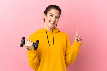 Young sport girl making weightlifting over isolated pink background showing and lifting a finger in sign of the best