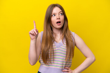 Young caucasian woman isolated on yellow background thinking an idea pointing the finger up
