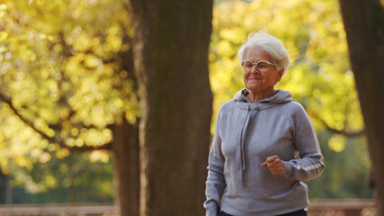senior woman jogging in park medium shot copy space healthy lifestyle . High quality photo