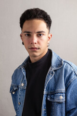 Obraz premium Model Young man with curly hair and confident pose wearing a denim jacket