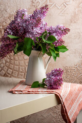 Blooming purple lilac in a white jug