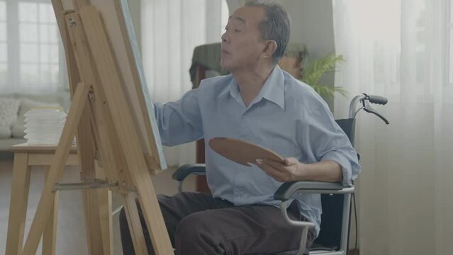 Artist concept of 4k Resolution. Asian man painting in the living room. Artist is creating work. Leisure activities and hobbies.