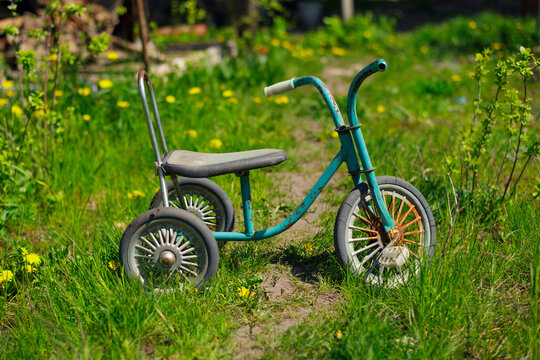 old children tricycle left among the grass