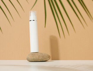 white plastic cosmetic bottle with dispenser and transparent cap on brown background. Packaging for cream, fluid and gel