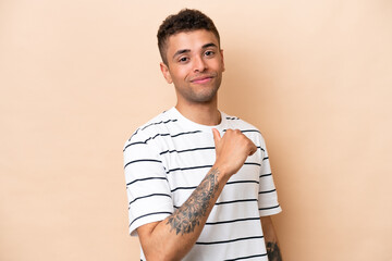 Young Brazilian man isolated on beige background proud and self-satisfied