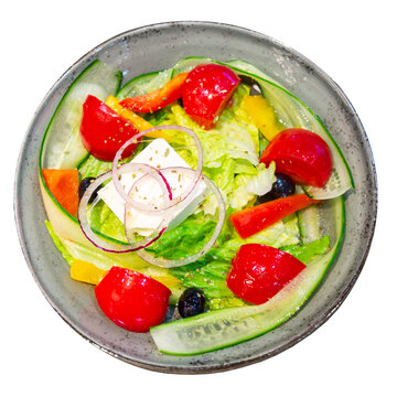 Fresh Greek salad with onion, bell pepper, feta cheese, tomatoes and olives isolated on white background. Top view.