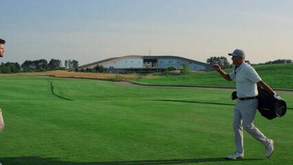 Golf players shaking hands on grass field. Two friends meeting play on weekend.