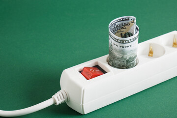 surge protector and money on a green background, electricity bill concept, electricity price...