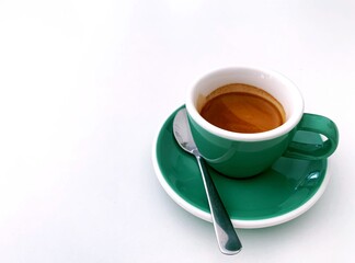 green mug of espresso shot on white table background. Morning coffee , refreshing , relaxing