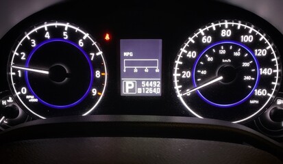 Modern Car Dashboard Lights Close-up Instrument Cluster Odometer, Speedometer & Tachometer Gear Selector MPG MPH KPH Analog Display / Automotive Gauges / Black Background