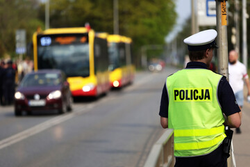 Policjant ruchu drogowego podczas zatrzymania pojazdów na drodze z tarczą do zatrzymywania - obrazy, fototapety, plakaty