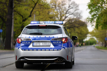 Radiowóz polskiej policji w mieście podczas patrolu na sygnale alarmowym. 