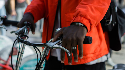 Fototapeta na wymiar Detail of the hands of an unrecognizable person using a bicycle in the city. 