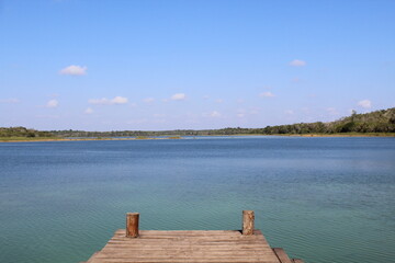 Fresh water lagoon with wood dock and blue sky on a bright sunny day in the Yucatan peninsula
