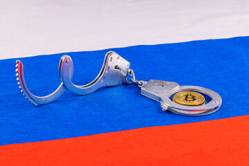 bitcoin shiner chained with handcuffs on russian flag background - crypto ban law concept.
