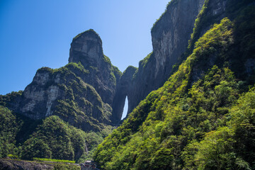 Horizontal wallpaper shot of the Tianmen cave covered with green forest in Zhangjiajie, Hunan, China, copy space for text