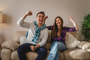 Two people couple man and woman young adult husband and wife or boyfriend and girlfriend happy celebrating success and achievement in their new apartment happy smile real people copy space
