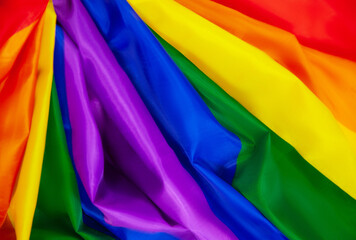 Rainbow lgbtq pride flag made from silk material in horizontal photo.