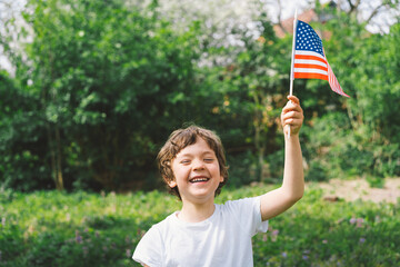 Happy little patriotic boy holding American flag. USA celebrate 4th of July. Happy independence day