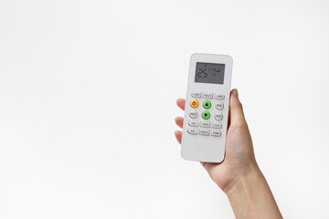 Woman's hand holding remote control of air condition that has been adjusted to 25 degrees Celsius over white background.