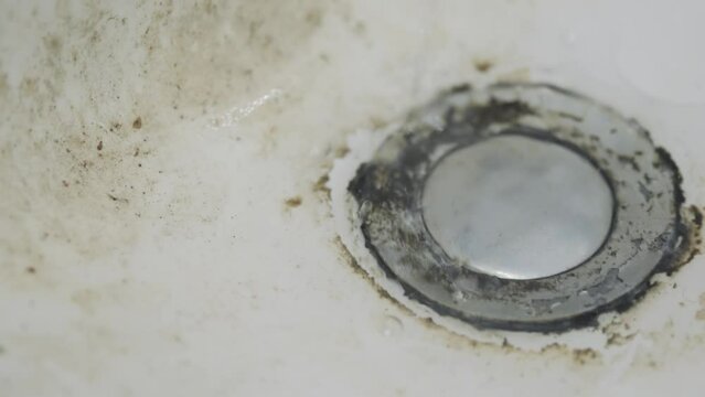 Dirty sink drain or wash mesh hole with rust and grunge from water in the bathroom.