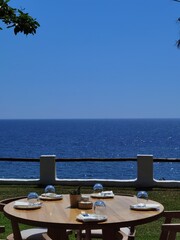 table of restaurant by the sea under the shadow of green trees greece preveza perfecture