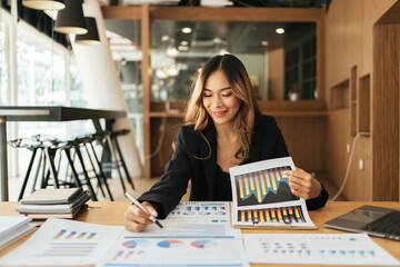 Business woman working in office with documents, Businesswoman reading financial graph charts...