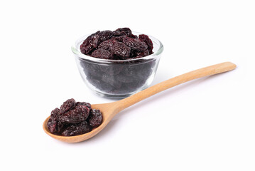 Raisins in glass bowl and wooden spoon isolated on white background