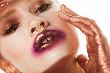 Beauty model female with bright fashion make-up touches face with fingers.