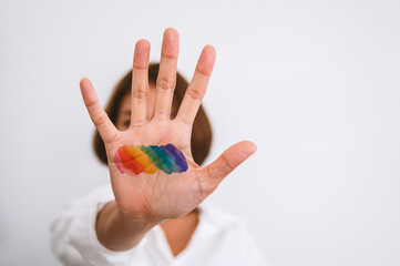 Young asian woman with the palm of her hand in front of her face with rainbow colors style LGBTQ, Concept lesbian, gay, transgender, bisexual.
