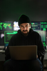 Hacker using laptop to organize malware attack on global scale.Vertical image.