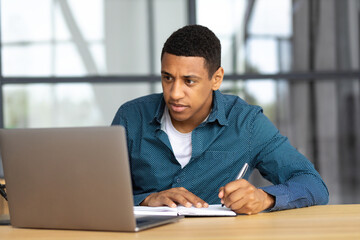 Distant work or online learning. Portrait of successful African American freelancer in coworking space during video conference. Video call, online business meeting, briefing concept