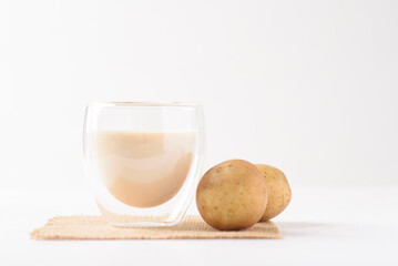 Potato milk in a glass, a healthy plant based drink on white background