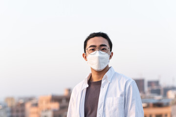 Asian young man wearing medical mask outdoors 