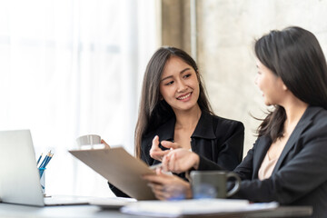 Asian business people meeting in office, Young broker businesswoman talking to business partners. Woman consulting, giving instructions, explaining terms of contract.