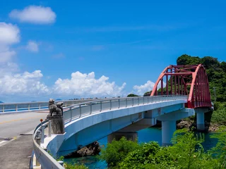 Fotobehang 晴れた暑い夏の沖縄県うるま市にある宮城島と伊計島をつなぐ赤い伊計大橋 © tnehala
