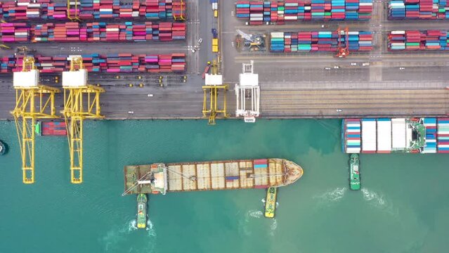 Aerial top view tugboat drag container ship in international shipping port footage 4k video from drone camera
