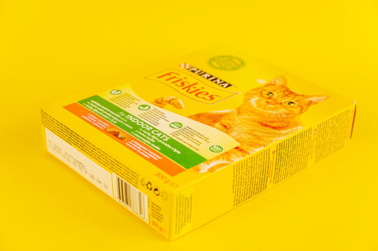 Purina Friskies cat food. Cardboard box with dry pelleted pet food. Yellow background. Selective focus. Ukraine, Mykolayiv - 05 25 2022