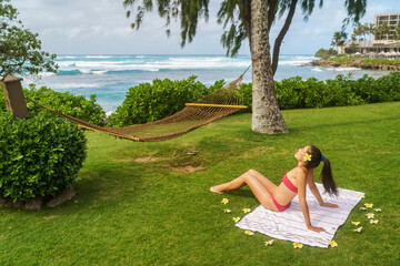 Summer vacation sunbathing bikini girl enjoying hotel holidays in Hawaii lying down on towel...